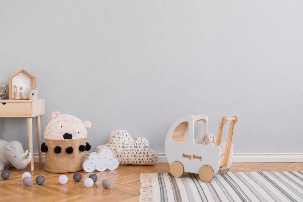 The wooden walker standing in a bright nursery alongside toys and a woven basket